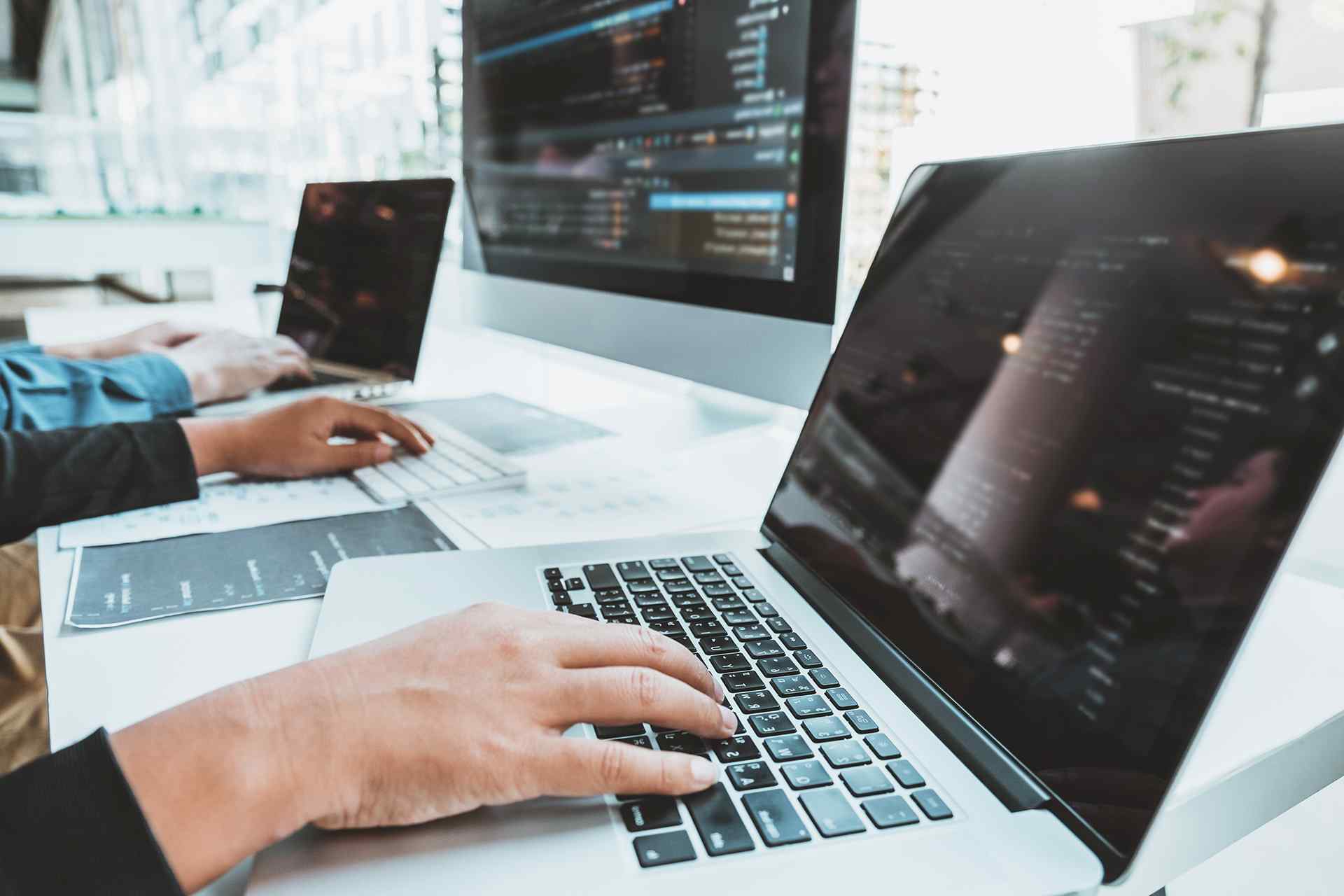 an employee with 2 monitors and 2 laptops